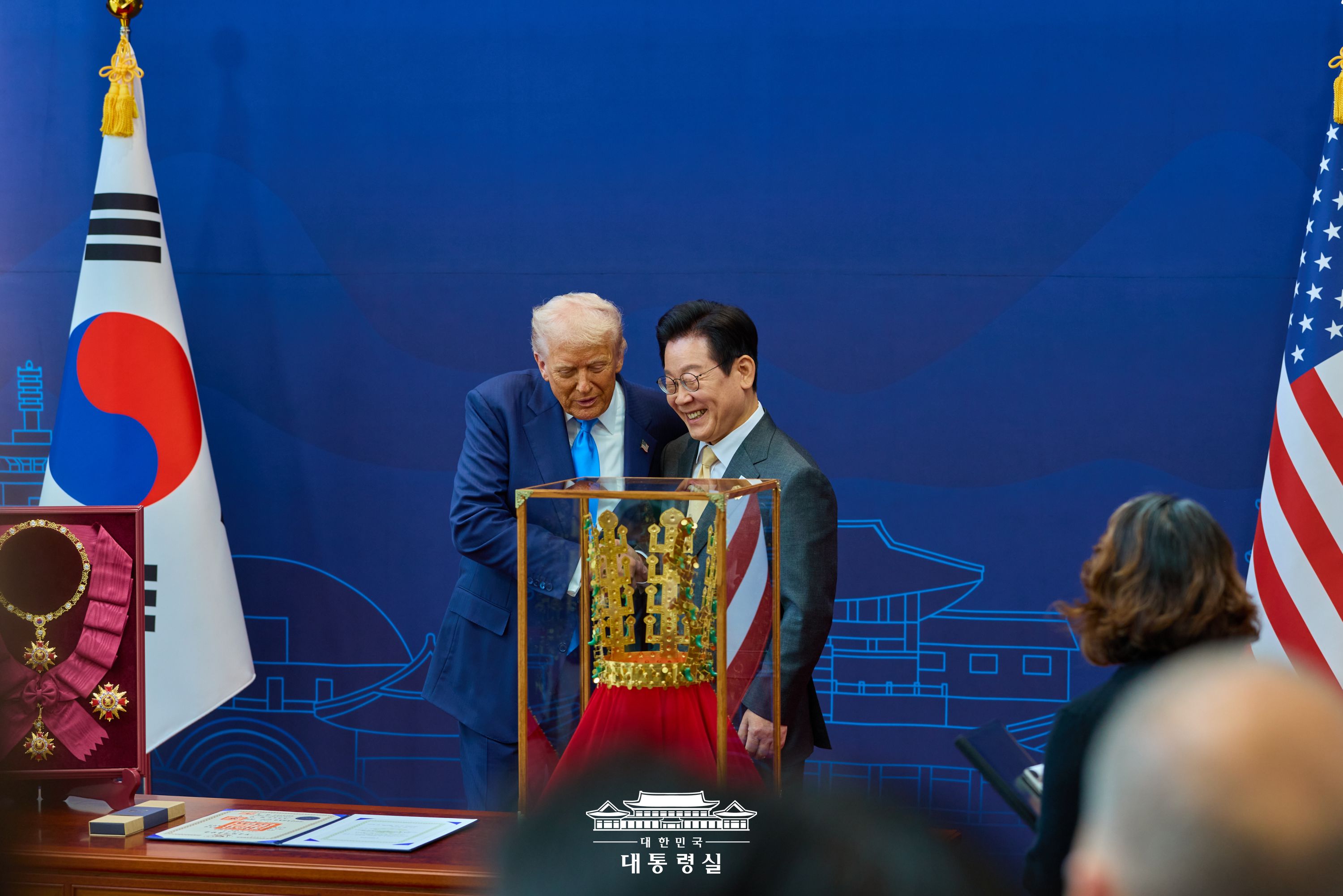 천마총 금관 모형 선물을 앞에 두고 웃으며 악수하는 이재명 대통령과 미 트럼프 대통령의 모습