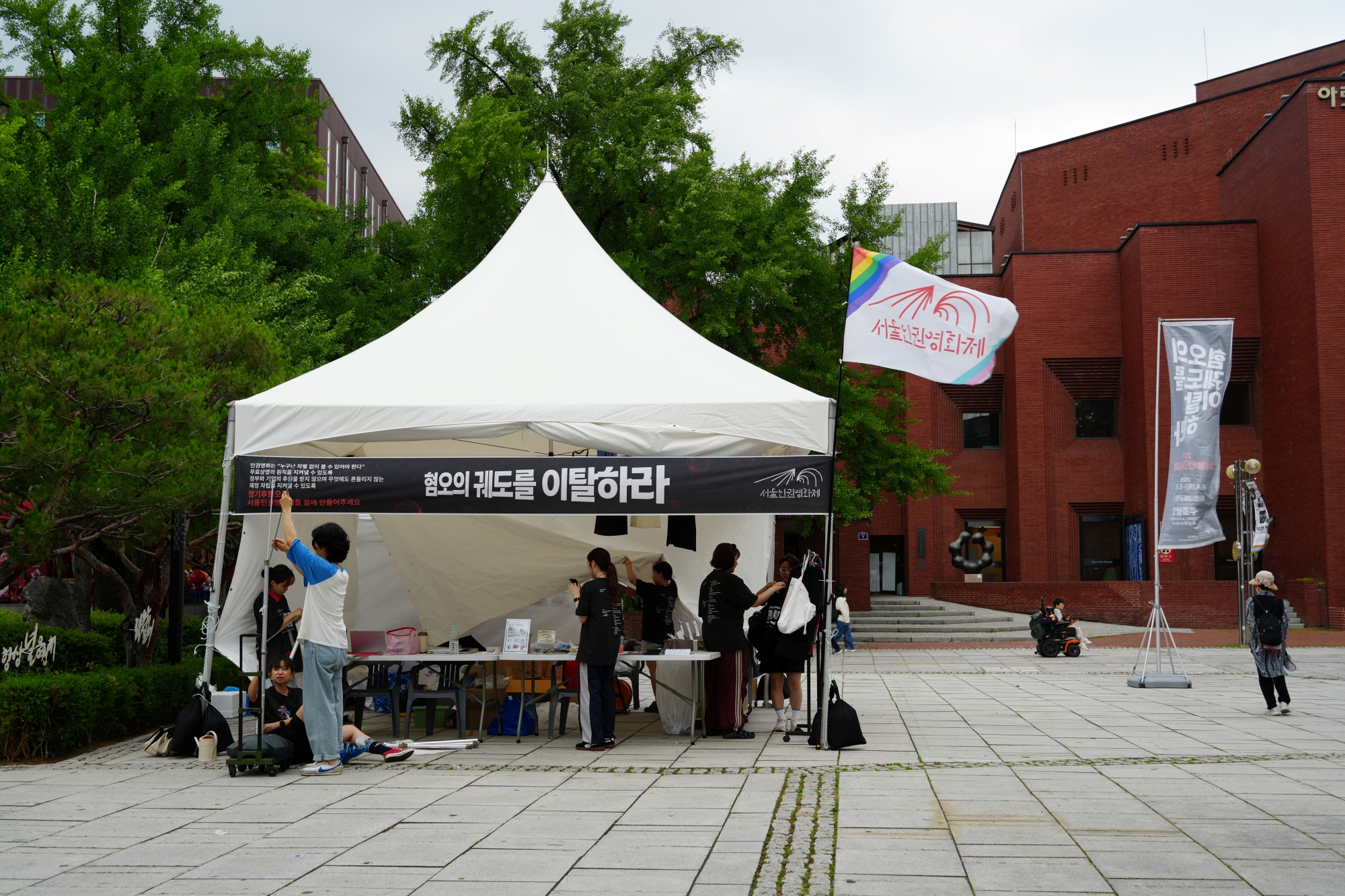 마로니에 광장의 서울인권영화제 부스. 혐오의 궤도를 이탈하라 라고 쓰여진 검정색 현수막이 가로로 걸려있다.