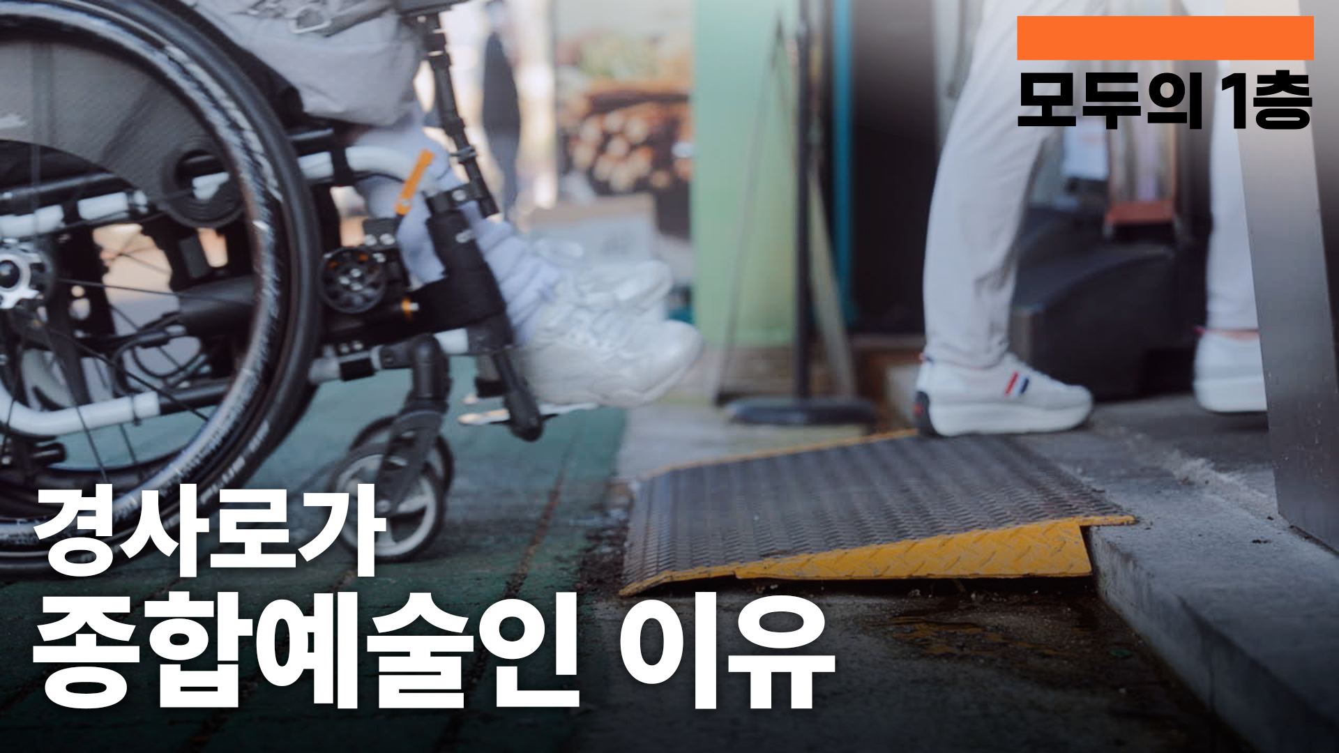 휠체어 이용자가 노란색 경사로를 통해 건물 출입구를 지나가려는  장면. 화면 상단에는 