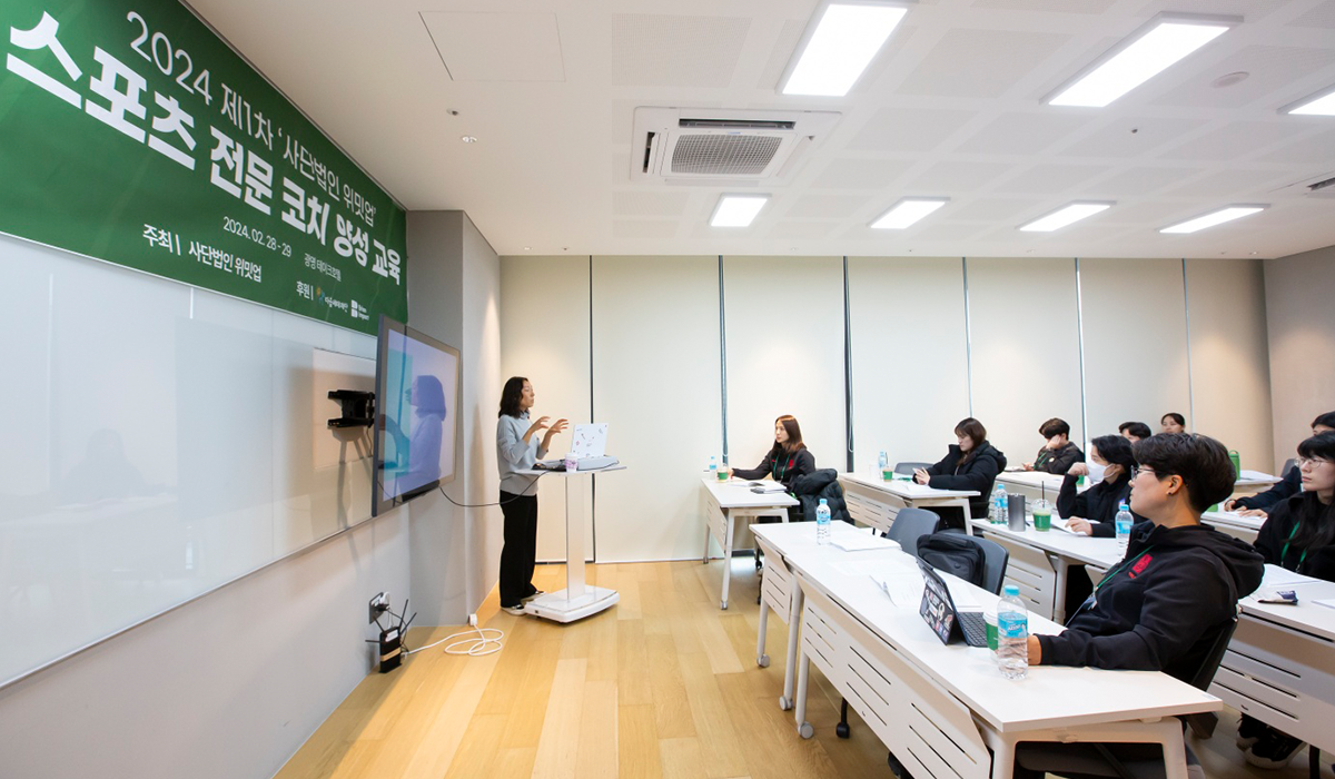 스포츠 전문 코치 양성 교육 진행 현장. 아이패드, 필기구 등을 지참한 교육 참여자들이 교육자에게 집중하고 있다.